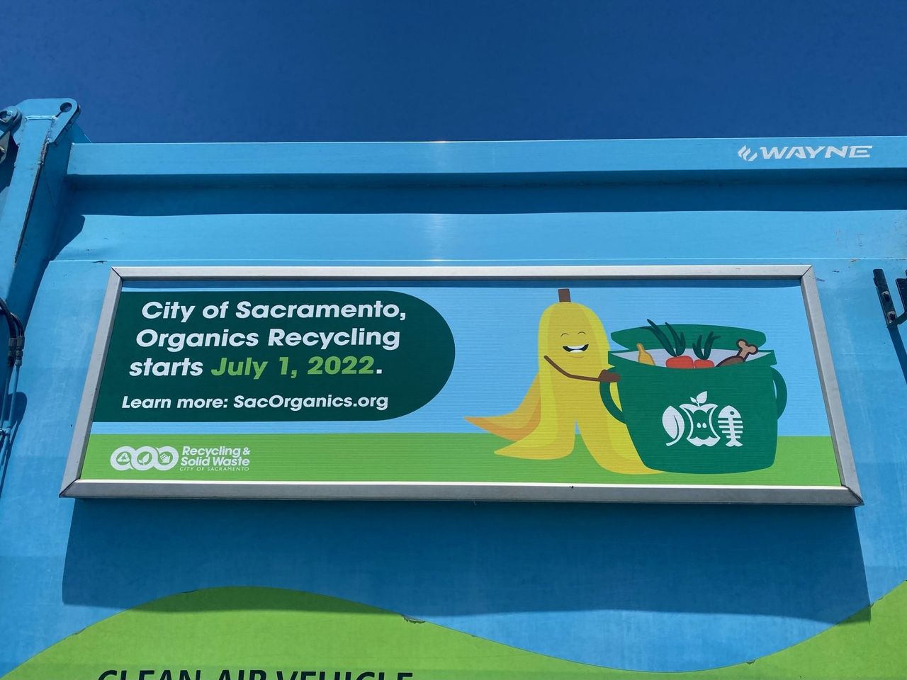 Program launch panel announcing the start date of Sacramento organics recycling, mounted in a Roadway frame