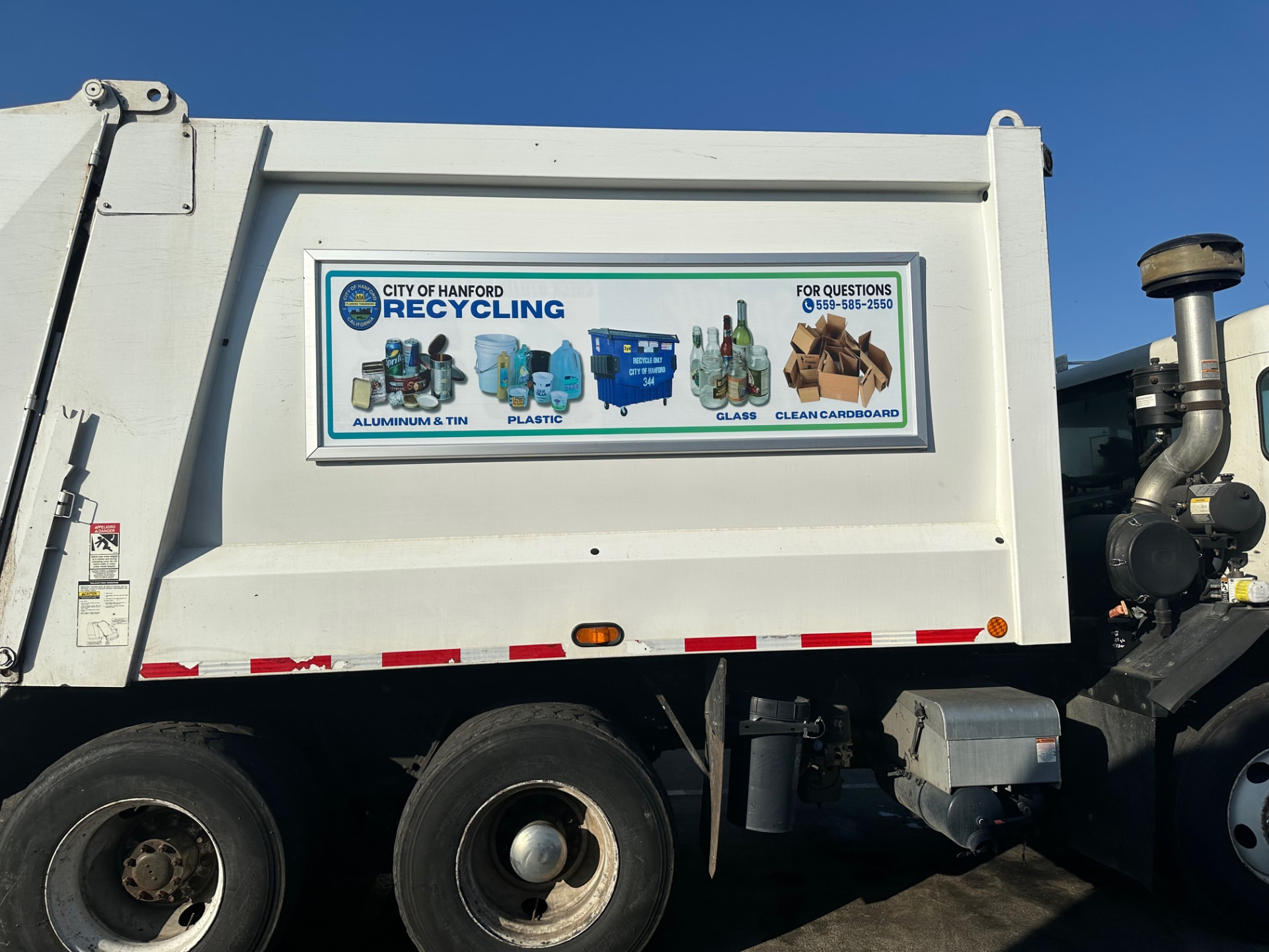 City of Hanford recycling guidelines panel mounted in a Roadway Displays frame on a white refuse truck